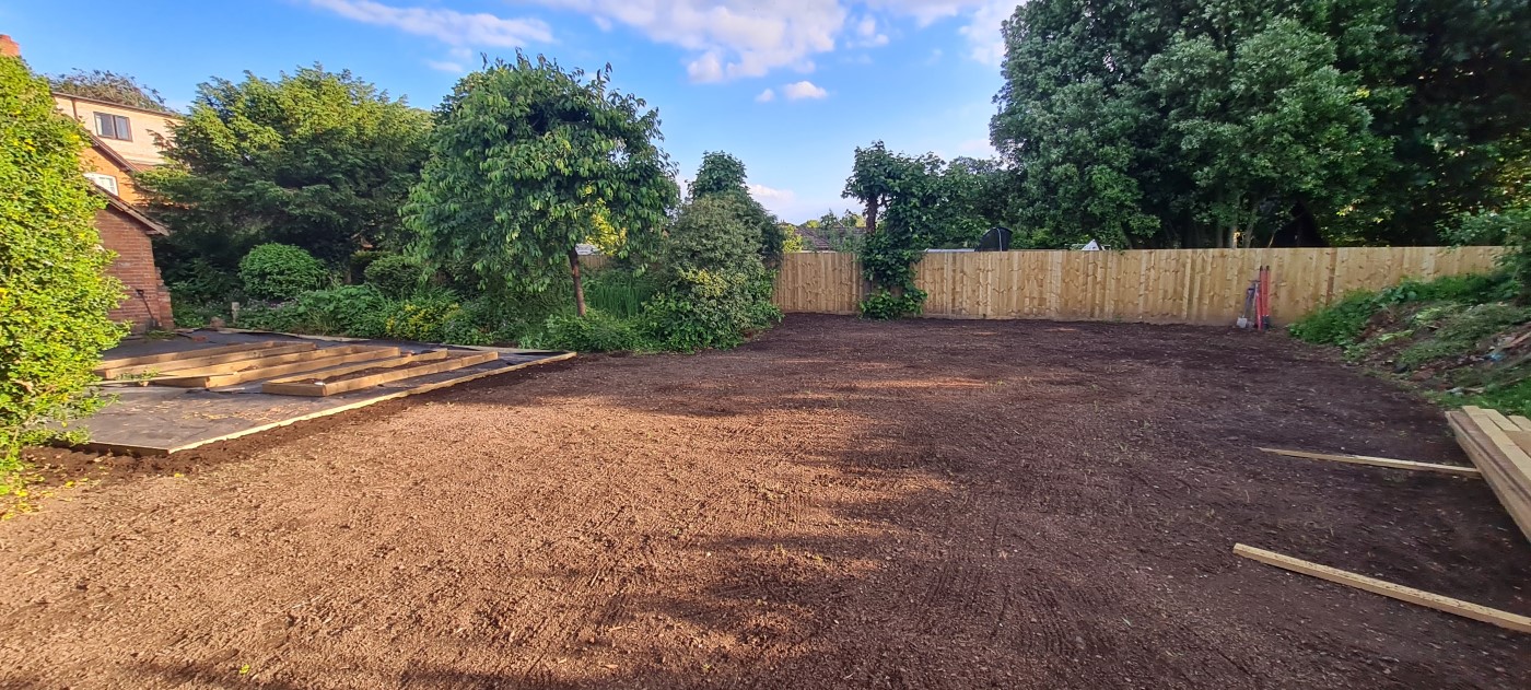 Large area of soil, which is now level and ready for new turf.